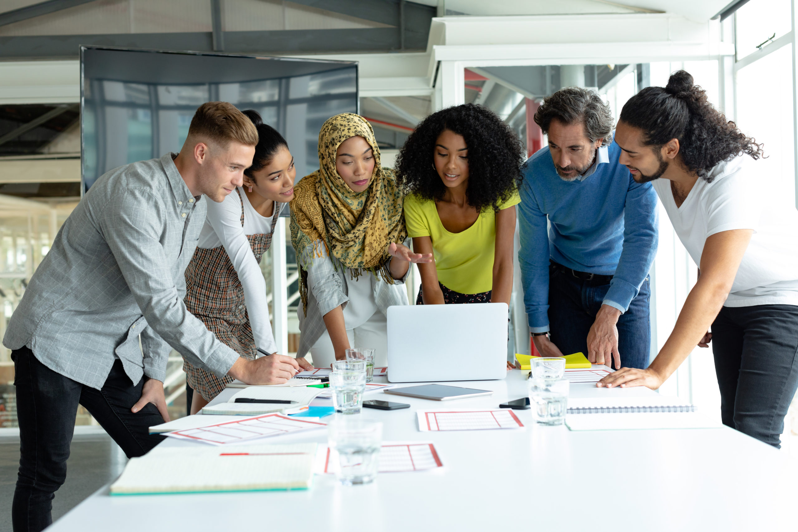 6 diverse co-workers viewing a laptop